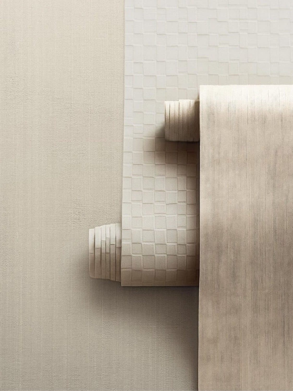 Rolls of textured wall covering unrolled against a papered wall